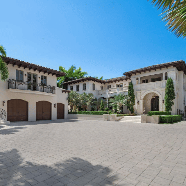 Detailed image of Grand Mediterranean Revival Estate Miami Luxury Motor Court Twilight View, a premier Exclusive Residence showcasing floor-to-ceiling windows in the exclusive gated Miami Beach neighborhood.