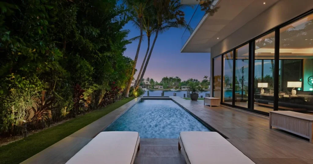 Detailed image of Miami Beach Modern Luxury Waterfront Villa Zero Edge Pool Patio at Dusk, a premier Waterfront Estate showcasing floor-to-ceiling windows in the exclusive South Beach neighborhood.
