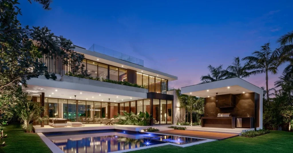 Detailed image of UltraModern Miami Beach Waterfront Estate Luxury Pool Outdoor Kitchen Twilight View, a premier Waterfront Estate showcasing floor-to-ceiling windows in the exclusive South of Fifth neighborhood.