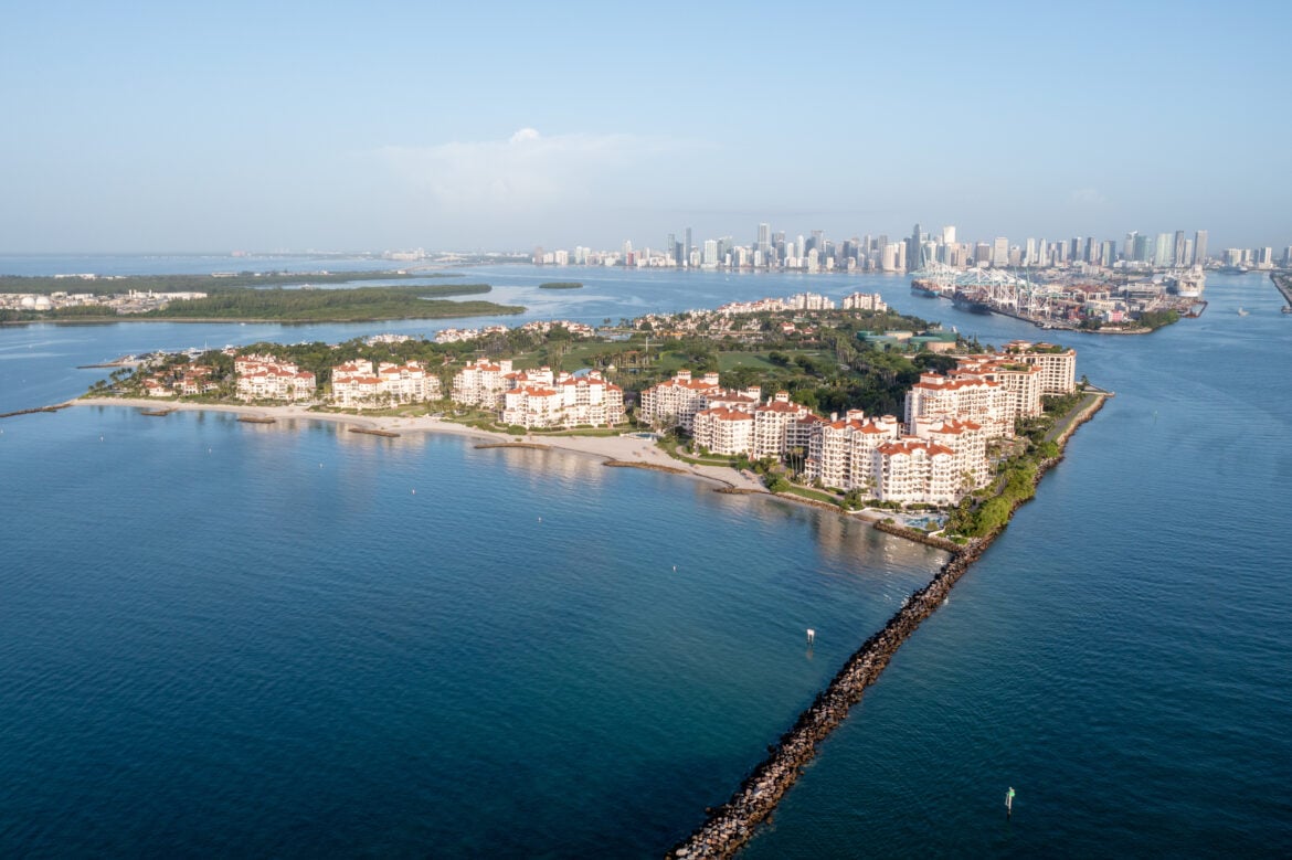 Aerial view of Fisher Island Miami at sunrise with downtown Miami skyline across Biscayne Bay