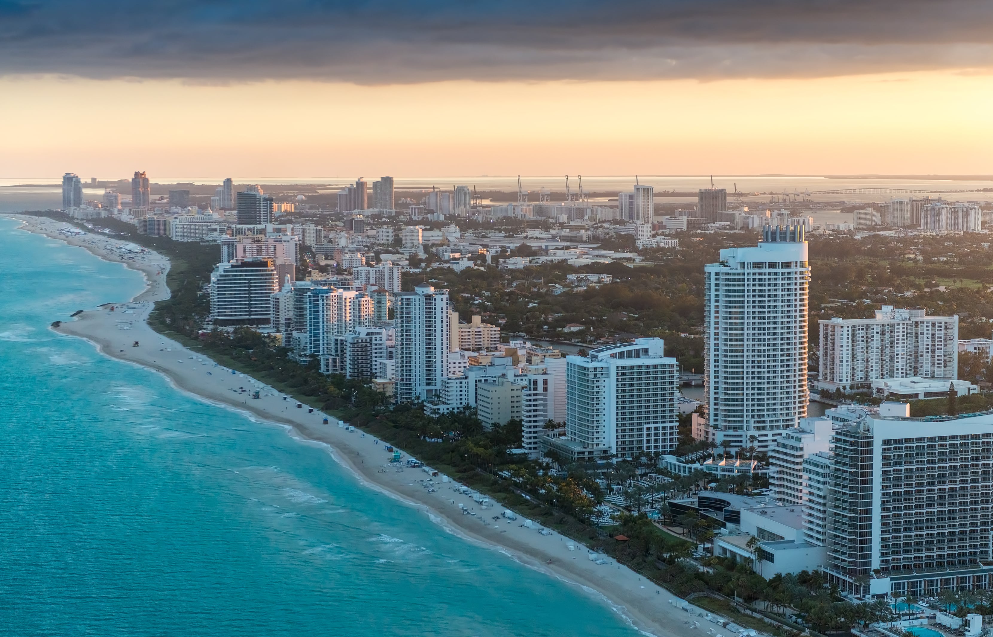 Miami Beach aerial sunset — luxury condos and oceanfront real estate along the Atlantic coastline