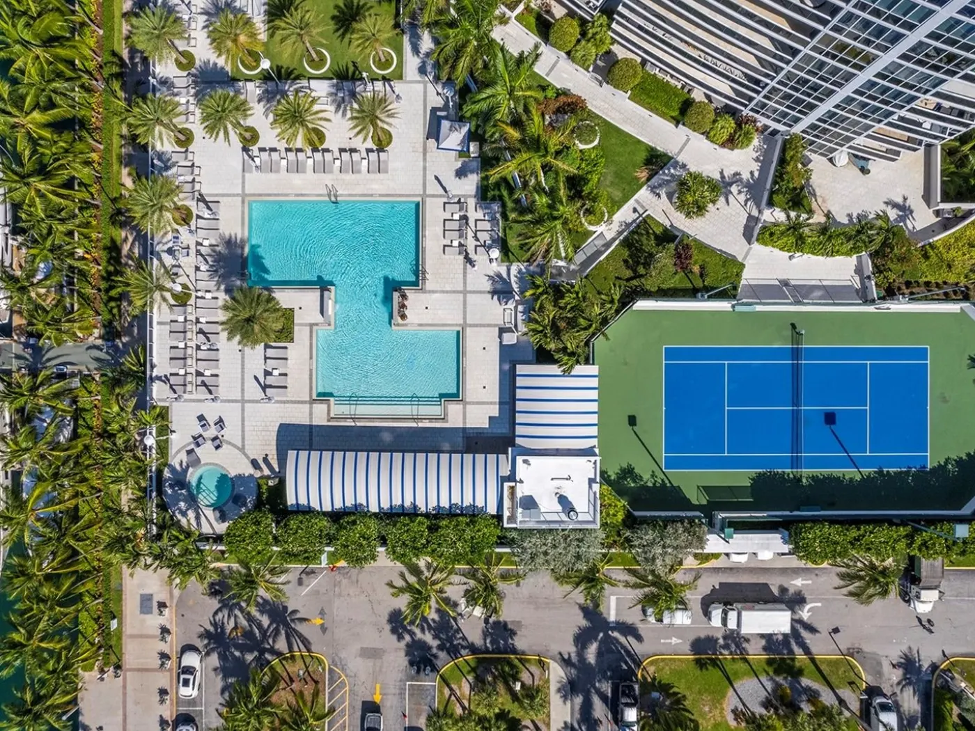 Overhead aerial of the Murano Grande pool deck, loungers and lighted tennis court