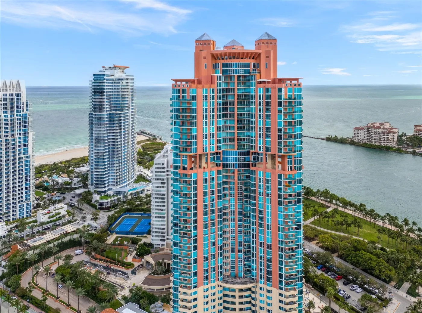 Portofino Tower coral and glass condo tower with South Pointe, Fisher Island and the Atlantic Ocean behind